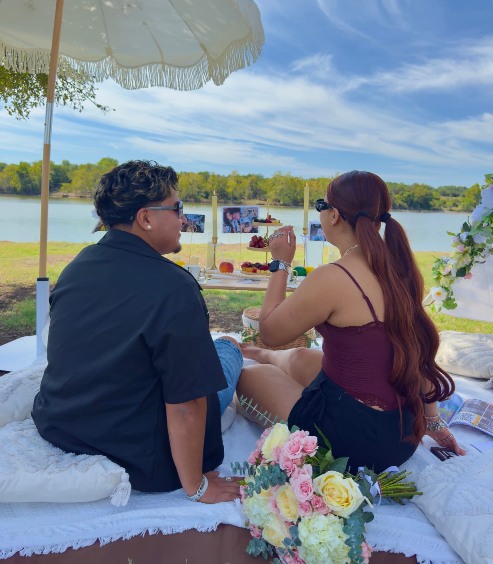 Couple enjoying a lakeside picnic with a rose bouquet in Austin