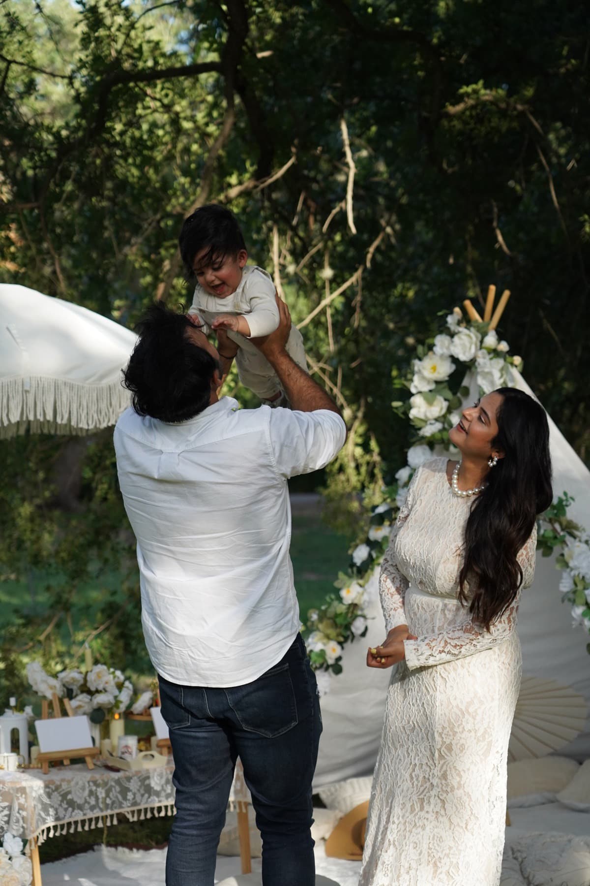 Family celebrating together at a boho picnic with a floral tent in Austin