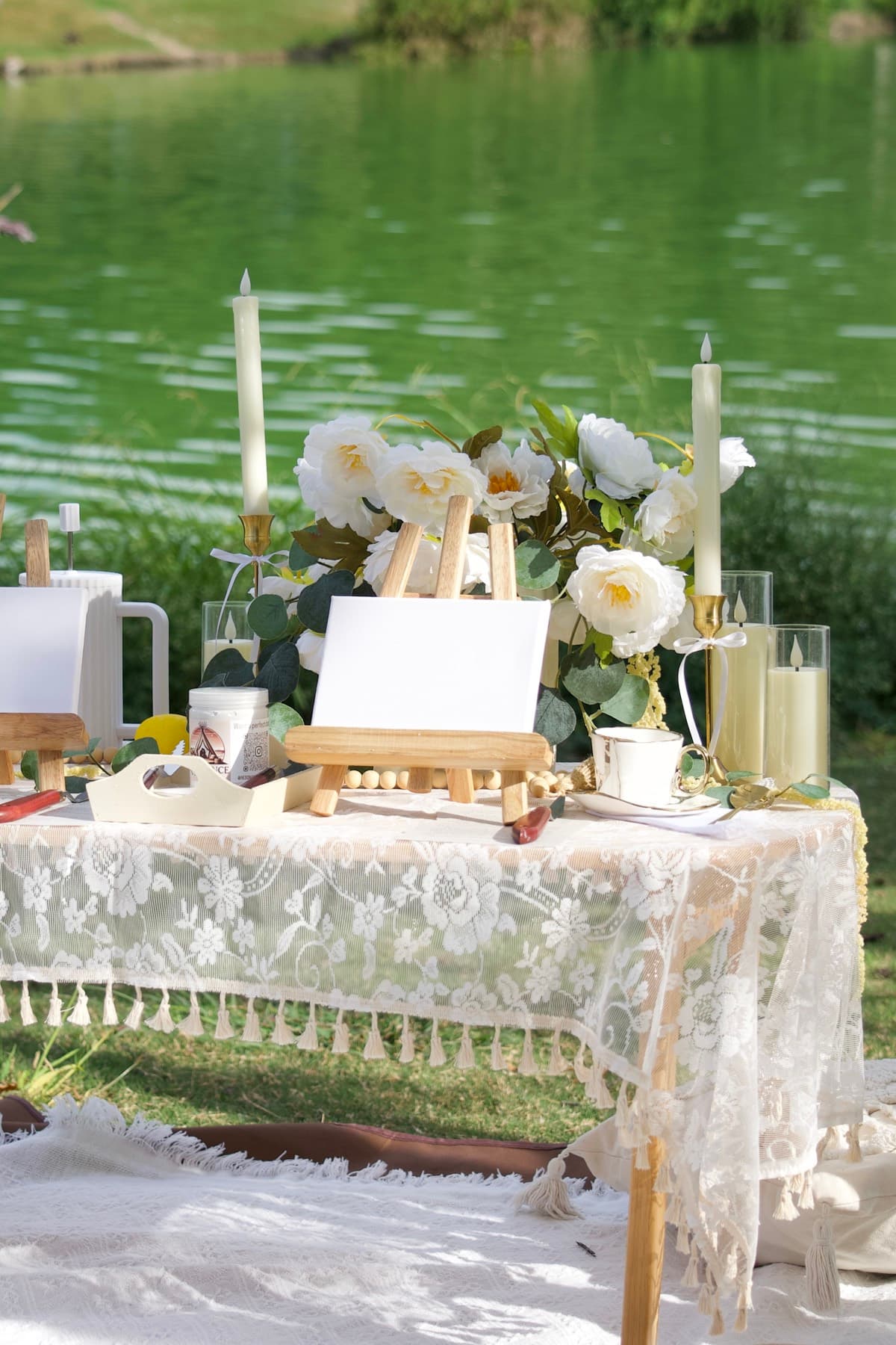 Elegant lakeside picnic table with painting easels and white peonies in Austin
